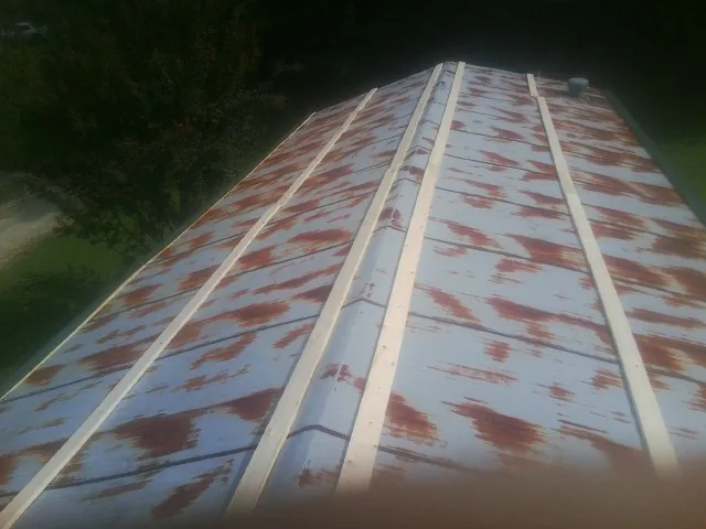 Rusted metal roof panels with new wood purlins before replacement — Storm Damage Roof Repair in Henry by Roofing Brothers